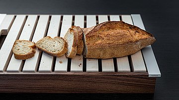 Brot auf dem bulthaup Brotschneidbrett, bei dem auch größere Krümel sicher hindurchfallen und aufgefangen werden.