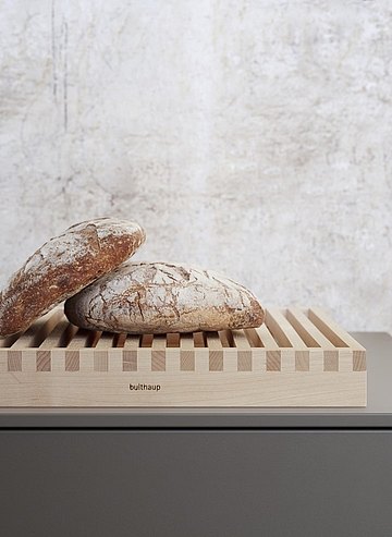 Brotkrümel verschwinden durch den durchgehenden Rost in die Auffangsschale